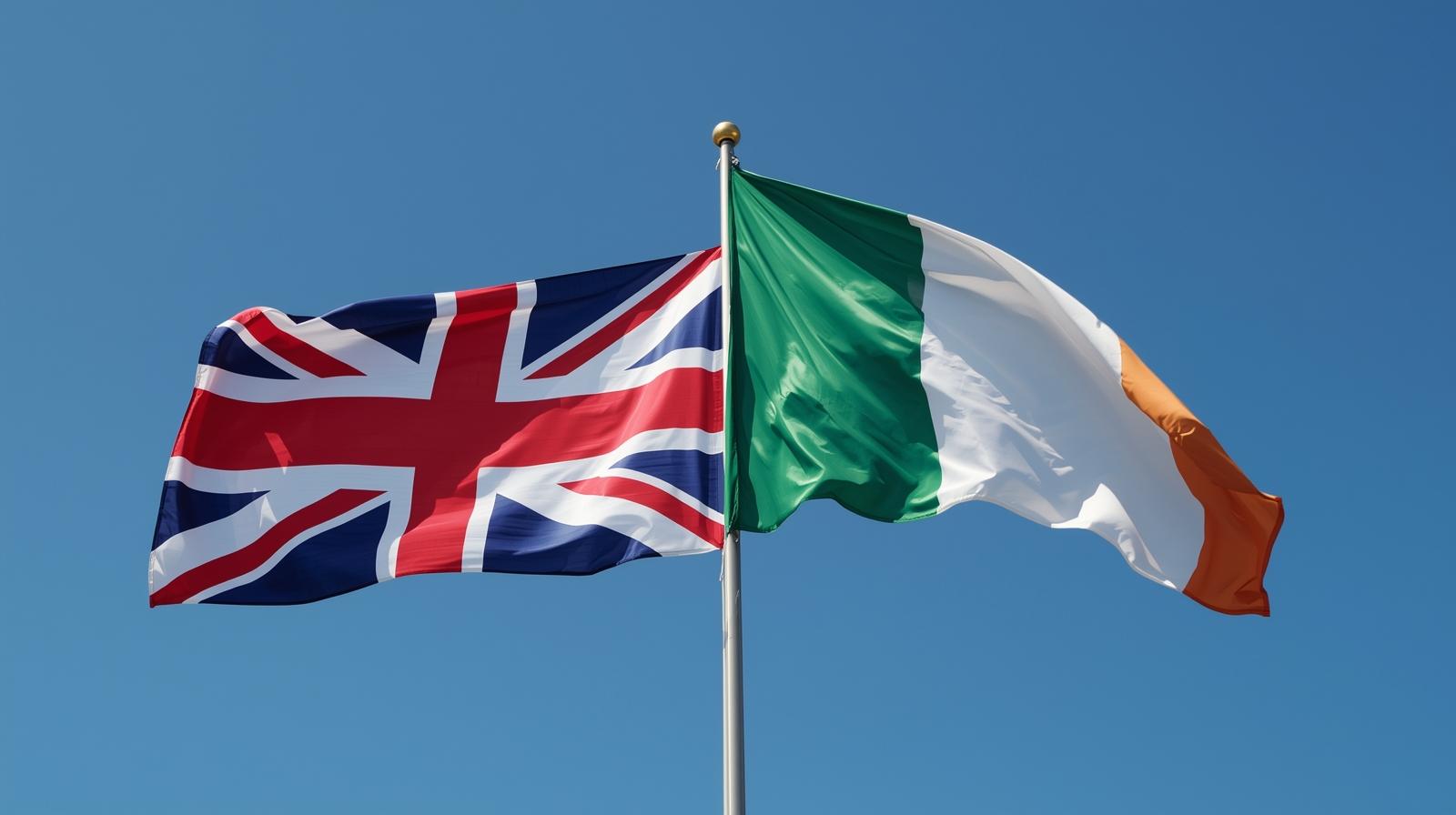 The flags of the United Kingdom and Ireland waving together under a blue sky, symbolizing the new easier British citizenship route for Irish citizens
